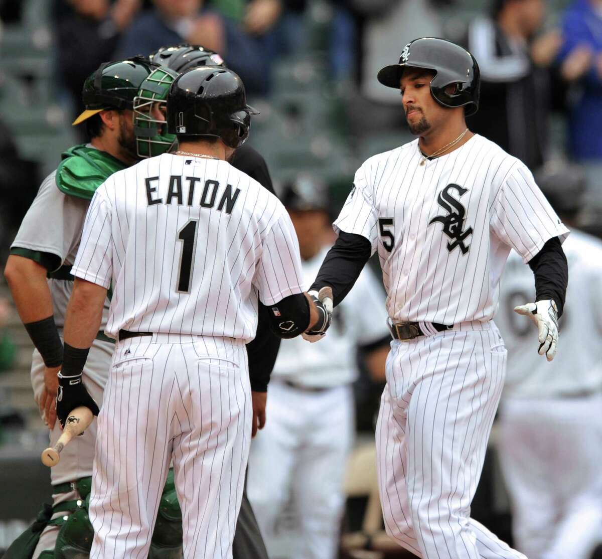 Chicago White Sox's Marcus Semien (5), celebrates with teammate Adam Eaton (1), after hitting a solo home run during the sixth inning of a baseball game against the Oakland Athletics in Chicago, Thursday, Sept. 11, 2014.