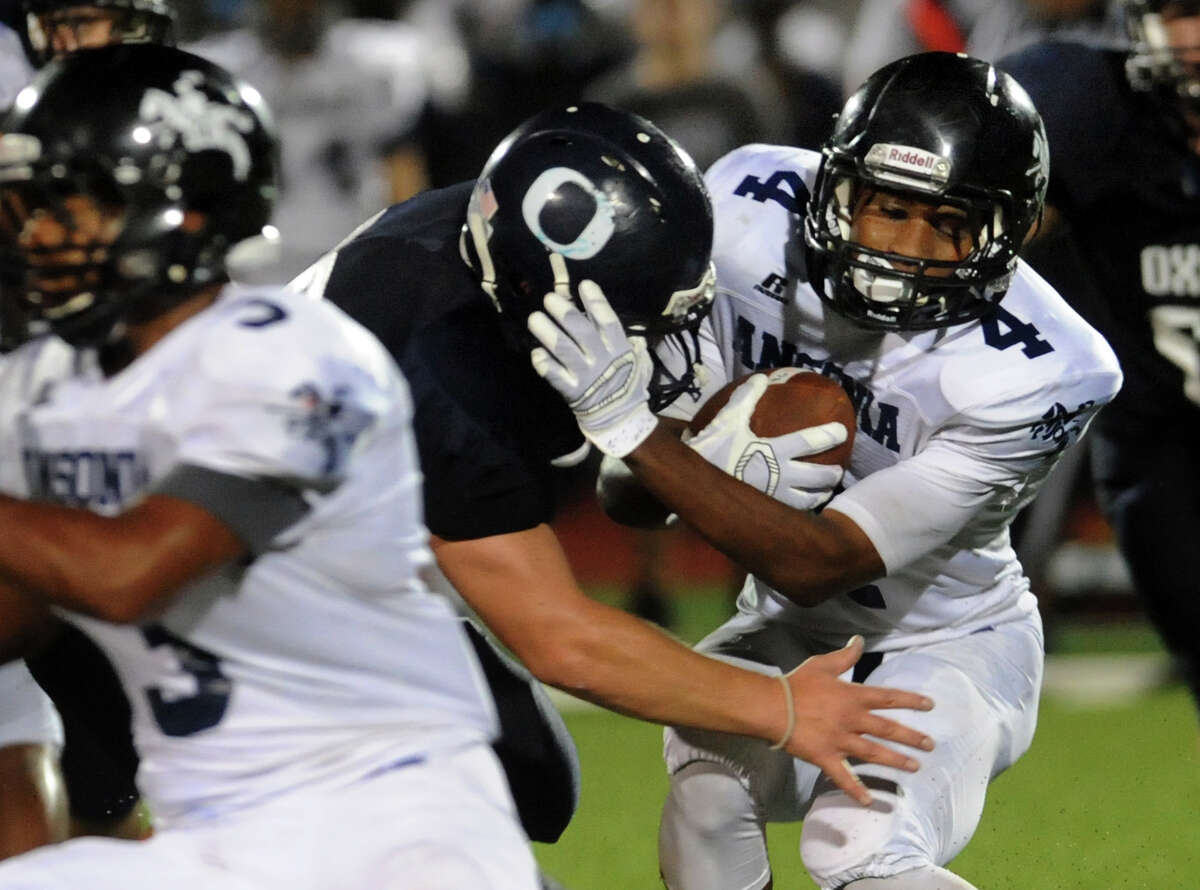 Ansonia's Tajik Bagley gets tackled by Oxford's Noah Lisewski, during high school football action in Oxford, Conn., on Thursday Sept. 11, 2014.