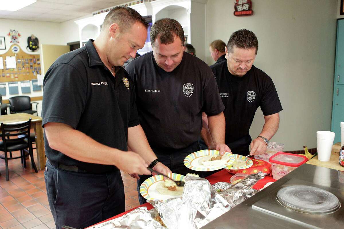 HFD engine operator Anthony Reynolds, firefighter Keith Tisdel, and engine operator Joe Hernandez help themselves to a second serving while H-E-B celebrates the 10th year of Helping Heroes where they provide breakfast for brave firefighters on Wednesday, Sept. 10, 2014, in Houston.