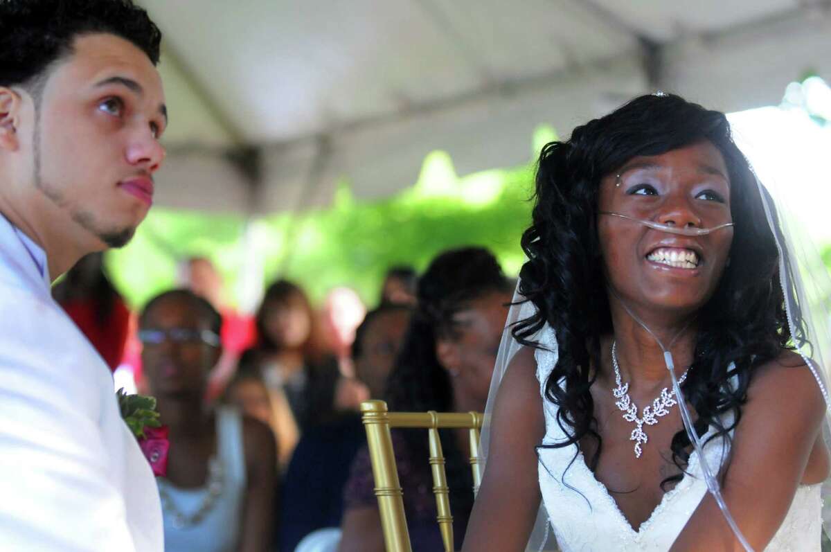 Jathyis Lajuett, left, and Jahaysia Graham are married at the Central Park Rose Garden Friday, Sept. 12, 2014, in Schenectady, N.Y. Nineteen-year-old Jahaysia is a patient of The Community Hospice. (Michael P. Farrell/Times Union)