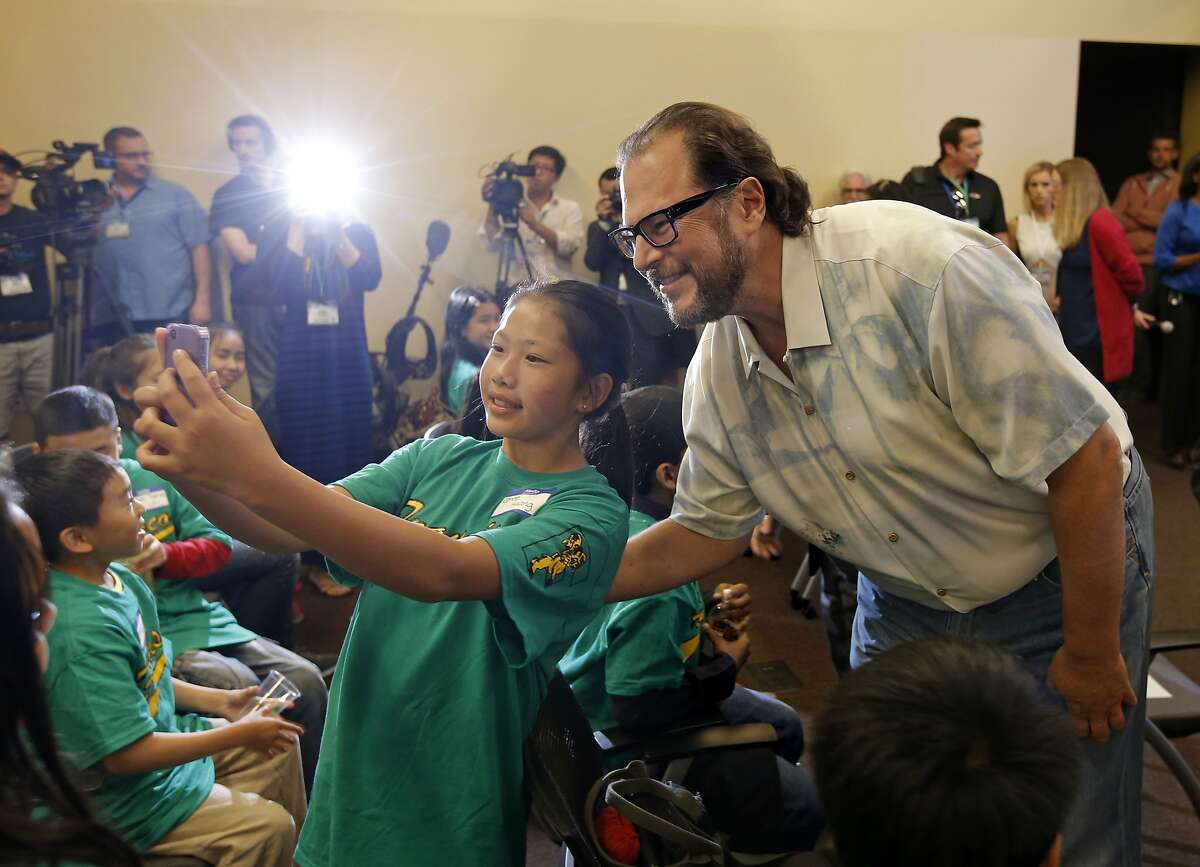 Francisco Middle School 6th grader Renee Huang, takes a selfie with Salesforce CEO Marc Benioff before the presentation at the Rincon Center in San Francisco, Calif., on Friday Sept. 12, 2014. Salesforce CEO Marc Benioff announces a new $5 million donation from Benioff which included money for 1,500 iPads for the city's twelve public middle schools as well as $100,000 for each middle school principal.