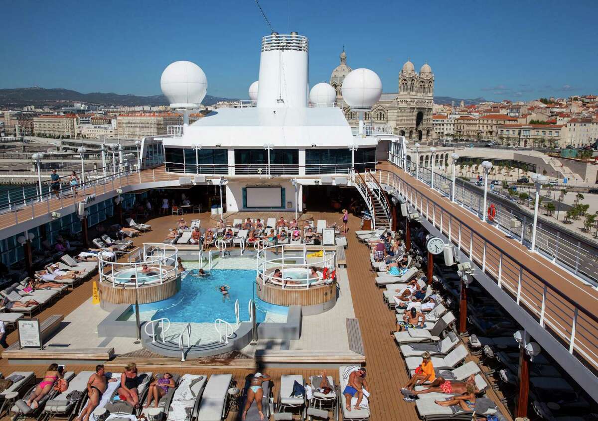 Guests on board the Azamara Quest lay out by the pool as the ship is docked in Marseille, France, during a Mediterranean cruise.