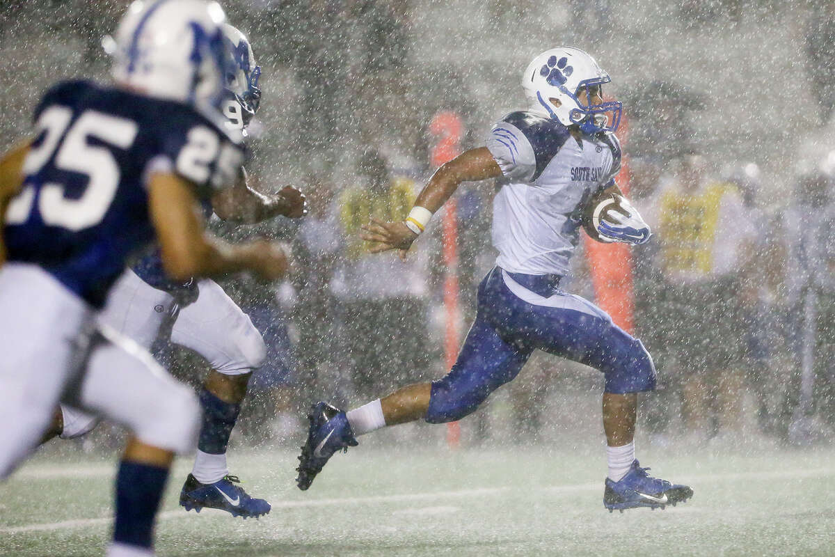 South San's William Sanchez (right) picks up yardage in the rain during the second quarter of their game with MacArthur at Comalander Stadium on Friday, Sept. 12, 2014. MacArthur beat the Bobcats 42-14. MARVIN PFEIFFER/ mpfeiffer@express-news.net