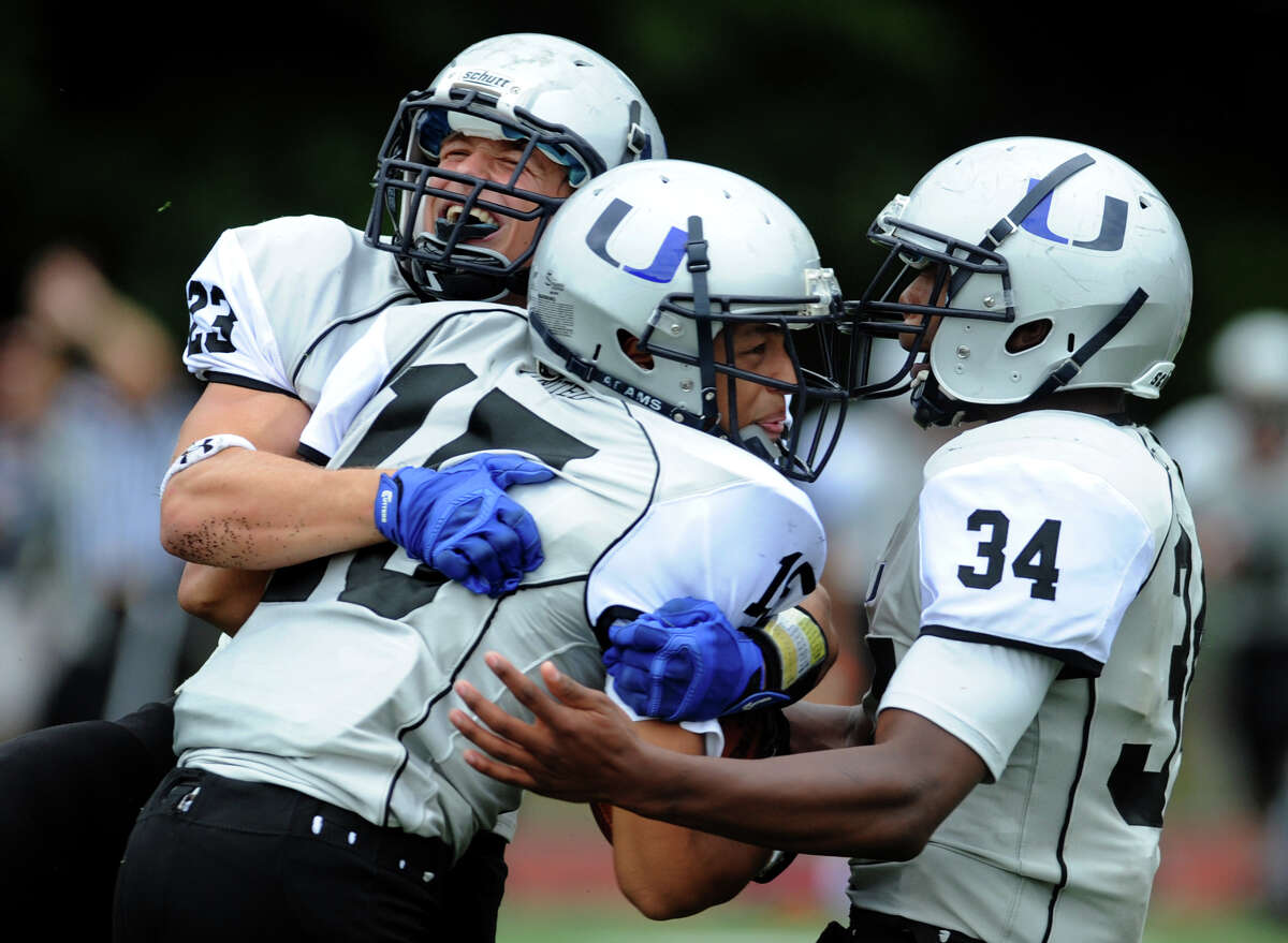 Abbott Tech/Immaculate's Darius Smith, center, celebrates with teammates after intercepting the ball from Platt Tech's Justin Ruiz, during high school football action in Milford, Conn., on Saturday Sept. 13, 2014.