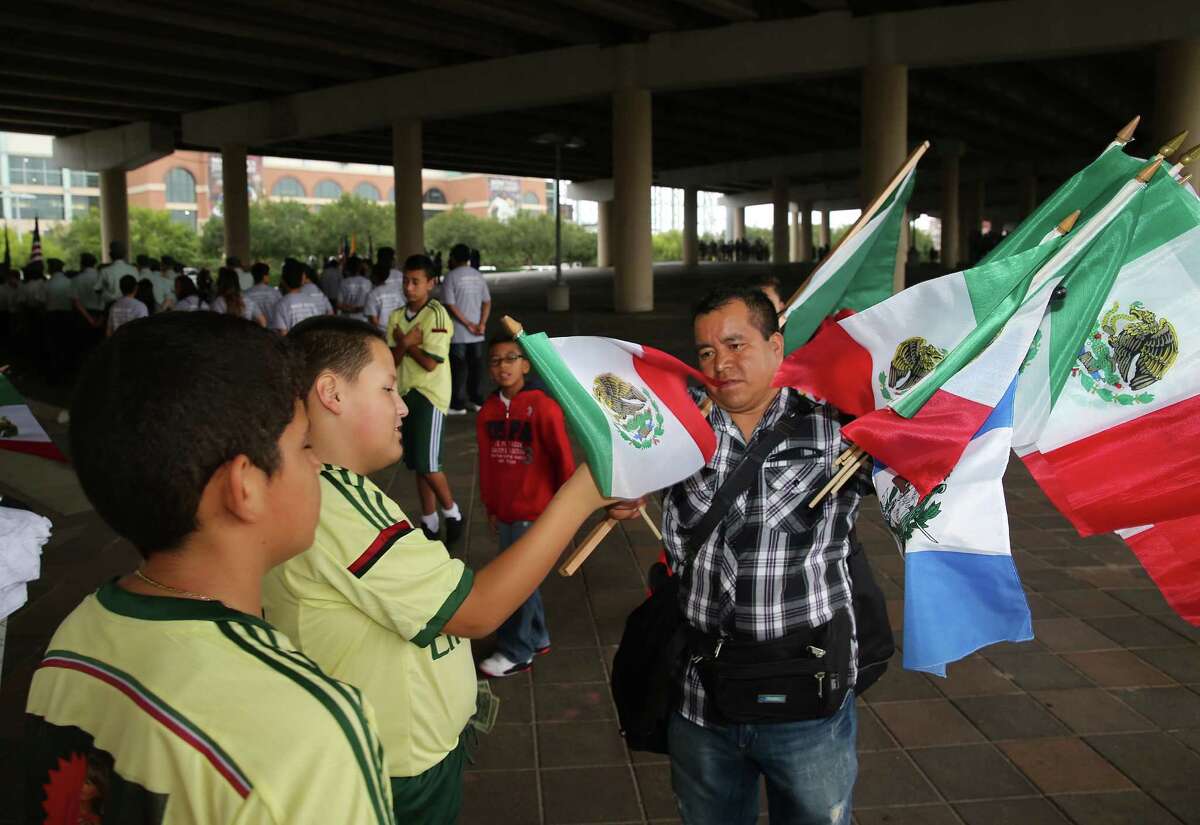 Yajdiel Guevara buys a Mexican flag from Obispo Diego before the start of the 46th Annual Fiesta Patrias International Parade in downtown Houston, TX.