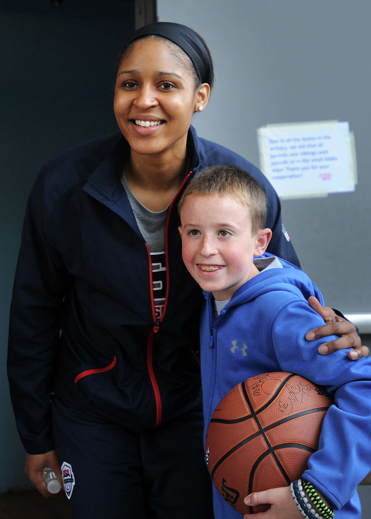 Former UCONN women's basketball and current WNBA star Maya Moore poses for a photo with fan Michael Eheman, Jr., 11, of Ansonia, outside the National Guard Armory in Ansonia, Conn on Sunday, September 14, 2014. A variety of former UCONN players were on hand for the filming of an ESPN documentary on the sport of women's basketball.