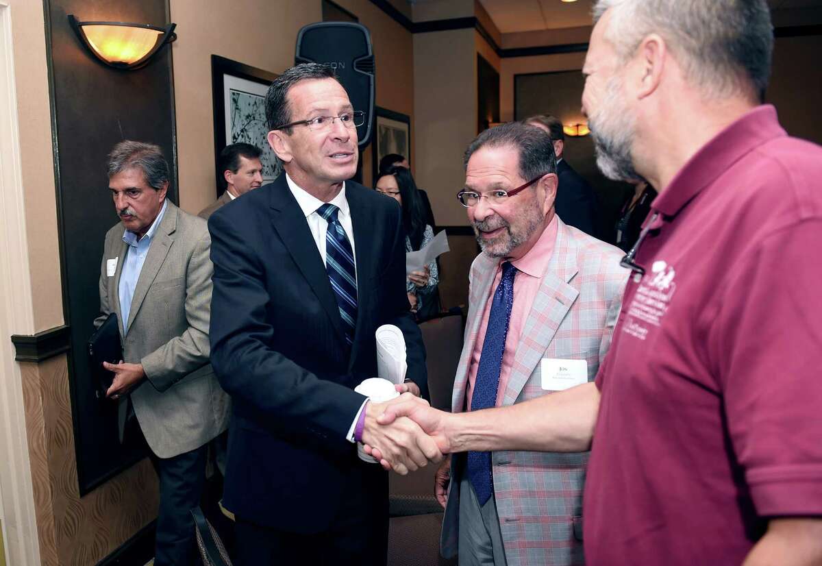Connecticut Gov. Dannel P. Malloy, center, shakes hands with Chip Beckett, Vice Chairman of the Capitol Region Council of Governments, at a Transportation Forum in North Haven, Conn., Monday, Sept. 15, 2014.
