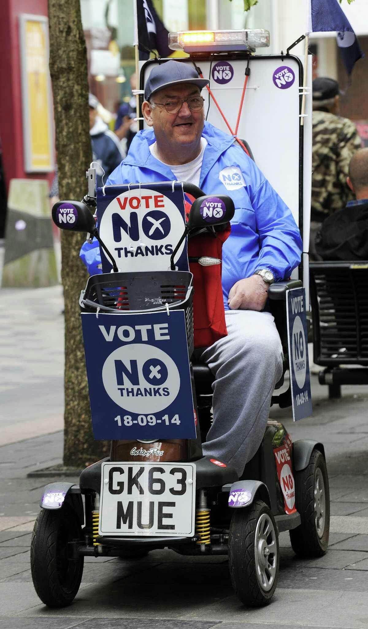 A Pro-union "No" campaign supporter rides his mobility scooter adorned with campaign placards in Glasgow on September 15, 2014, ahead of the Scottish independence referendum. The "Yes" and "No" camps are racing to win over undecided voters ahead of the historic poll on Scottish independence on September 18, 2014, with top bands playing a gig urging a vote for leaving Britain. AFP PHOTO/ANDY BUCHANANAndy Buchanan/AFP/Getty Images