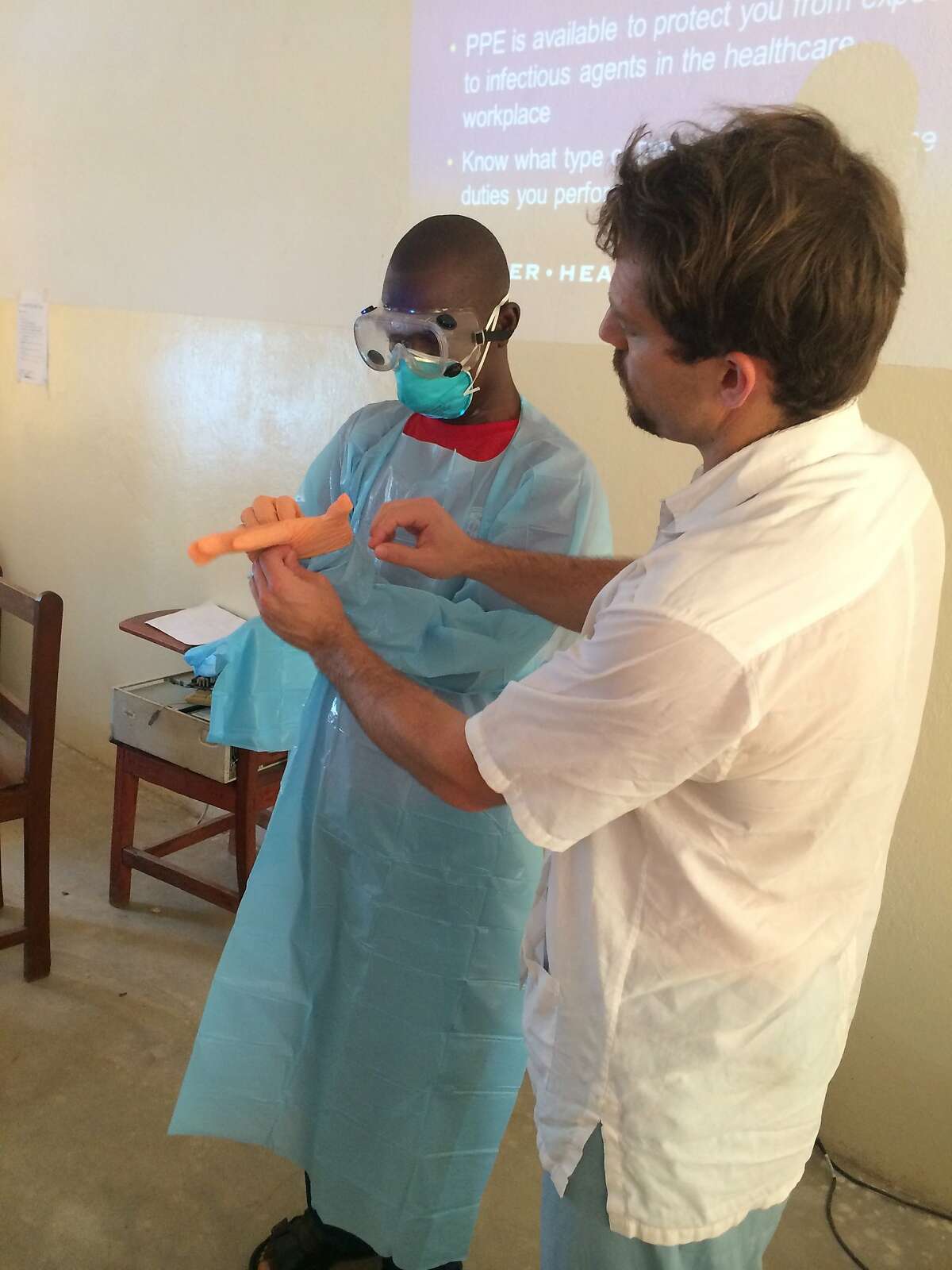 Dr. Dan Kelly of UCSF teaches a health care worker how to protect himself while treating Ebola patients in Sierra Leone.