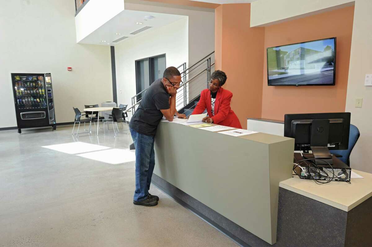 Receptionist Linda Price, right, helps someone at the Capital South Campus Center which is run by the Trinity Alliance of the Capital Region on Tuesday, Sept. 16, 2014 in Albany, N.Y. (Lori Van Buren / Times Union) f