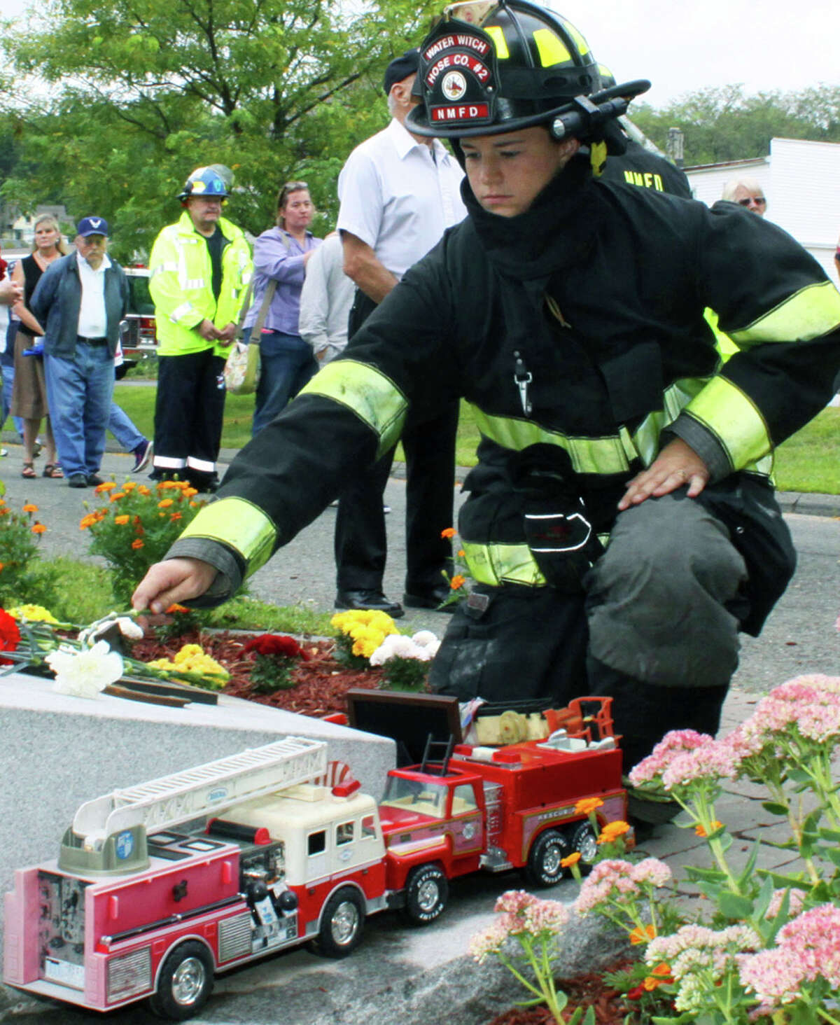In remembrance Thirteen years after the horrific terrorist attacks on the United States, residents throughout the Greater New Milford area paid tribute to those who died in New York City, Washington D.C. and Pennsylvania. Above, Water Witch Hose Co. No. 2 firefighter Maureen Hickey places a flower on the 9/11 memorial at Patriot's Way during New Milford's annual 9/11 service. For more photos, see the Sept. 26 edition of The Spectrum and visit www.newmilfordsectrum.com. For the story and photos from Kent's 9/11 ceremony, see Page S3. September 2014