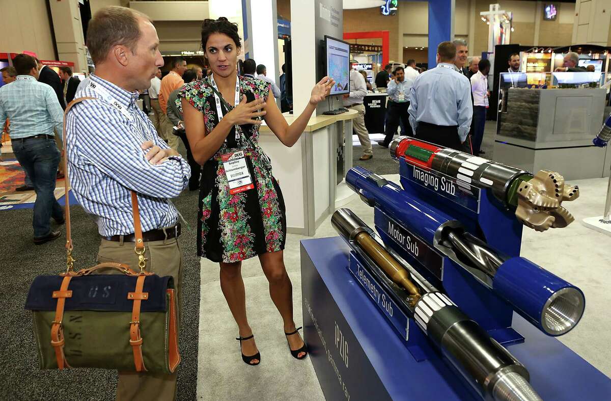 Sophie Jones, center, of Schlumberger, talks to Dave Milam of WellAware, infront of a drilling display at Hart Energy's DUG Eagle Ford Conference at the Henry B. Gonzalez Convention Center. Tuesday, September 16, 2014