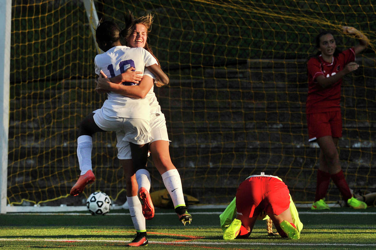 Westhill's Chelsea Domond, back to camera, and Jessica Laszlo embrace after Domond scored on Greenwich goalie Emma Barefoot during their game at Westhill High School in Stamford, Conn., on Wednesday, Sept. 17, 2014. Westhill won, 2-1.