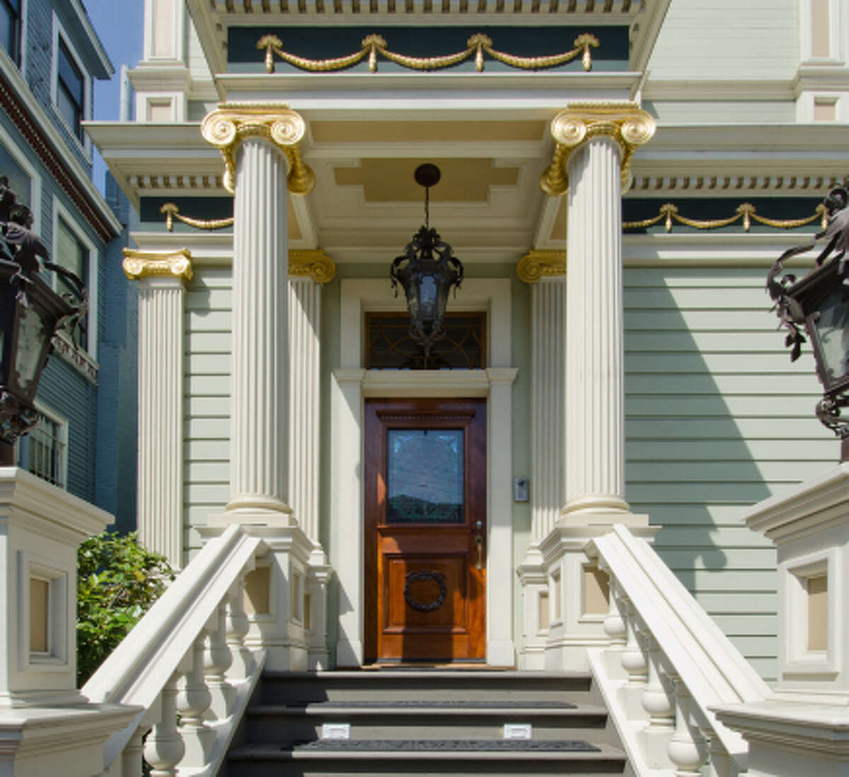 The Victorian features a portico flanked by gilded columns. 
