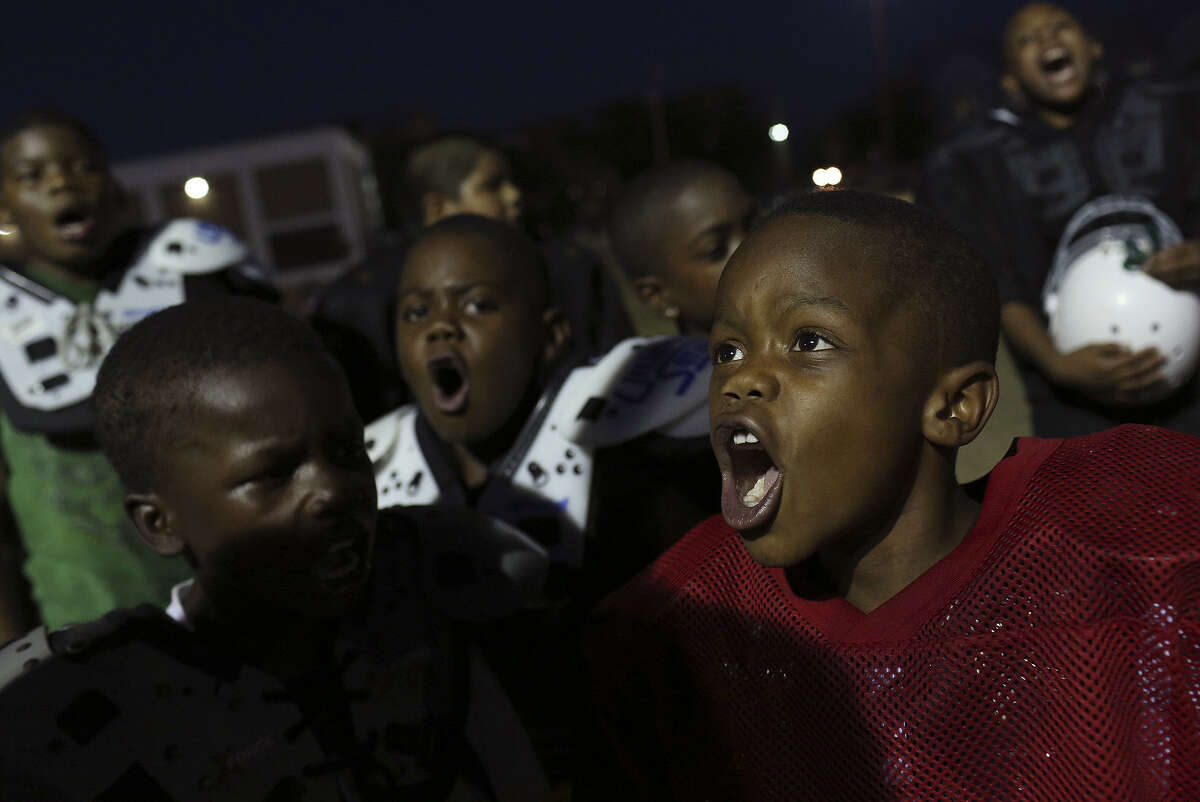 Keith Scott Jr. (right), 8, a member of an East Side youth football team, chants with his teammates. The team received a generous donation recently, and a reader is happy for the kids but not about their team name.