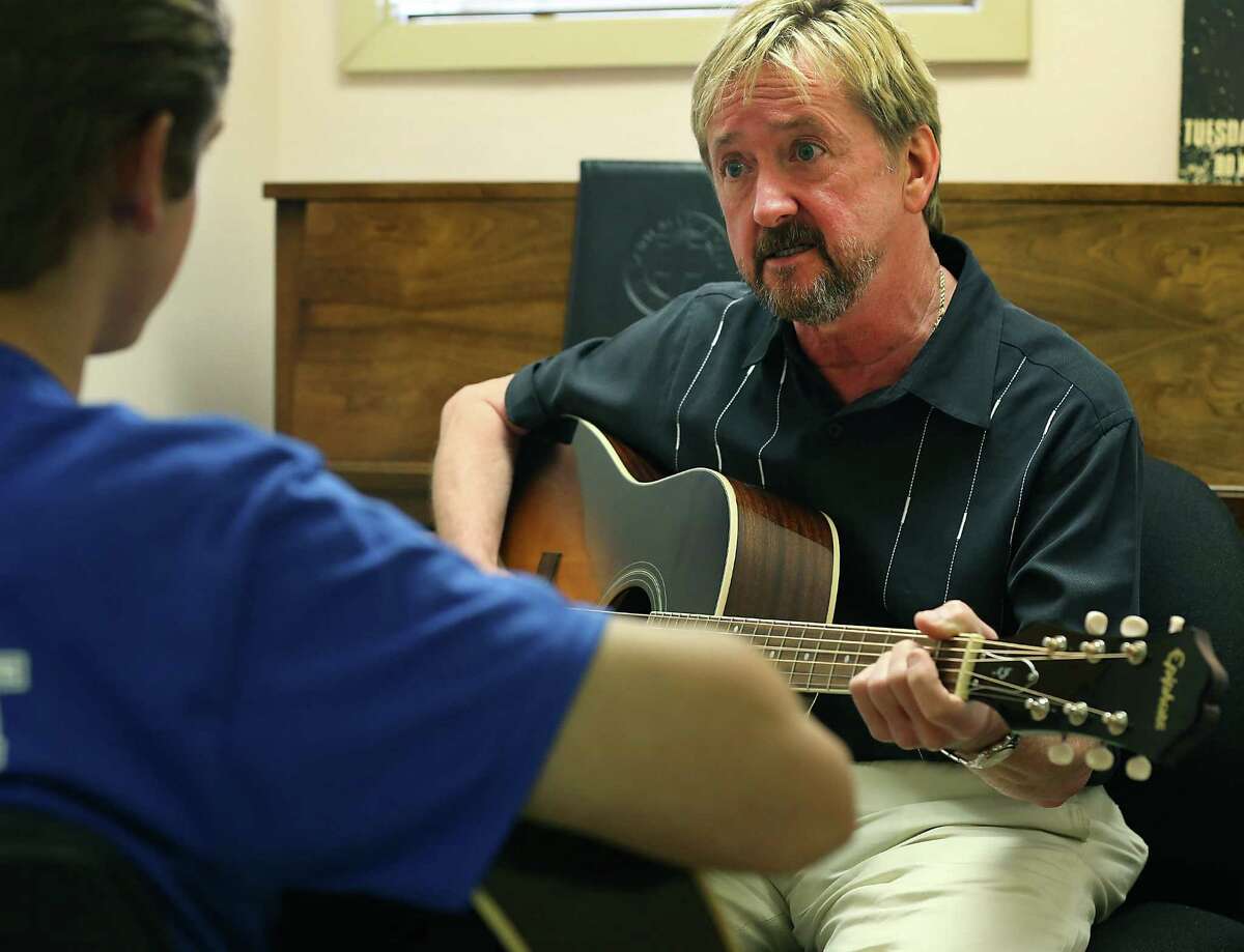 Steve Owens, guitarist with the Mo-Dels, teaches guitar to Jack Wright at Saint Mary's Hall. Wednesday, September 17, 2014