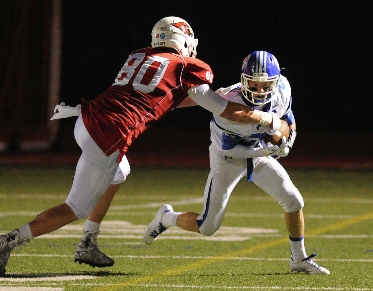 Darien's Hudson Hamill, right, attempts to get past Scooter Harrington (#80), after Hamill intercepted a pass during the high school football game between Darien High School and Greenwich High School at Greenwich, Friday night, Sept. 19, 2014. Darien defeated Greenwich, 33-26.