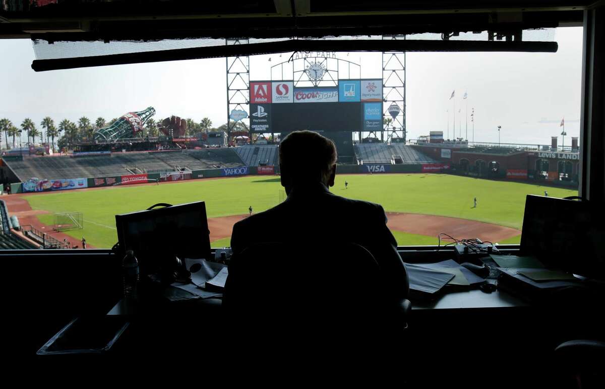 Vin Scully, above, finishes preparations to broadcast the Dodgers’ game against the Giants on Sept. 14 at AT&T Park. Scully, smiling at a colleague’s comment, below, was a Giants fan in his youth but has been working Dodgers games for 65 years.