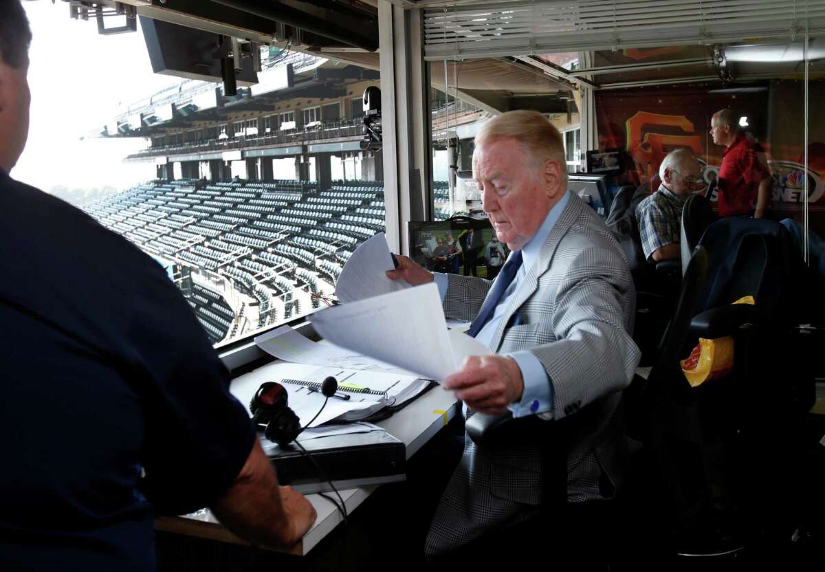 Vin Scully gets organized before the start of the game with some of his staff Sunday September 14, 2014 in San Francisco, Calif. Hall of Fame Los Angeles Dodgers announcer Vin Scully was at AT&T park for the last Giants series and after six decades is still in his prime.