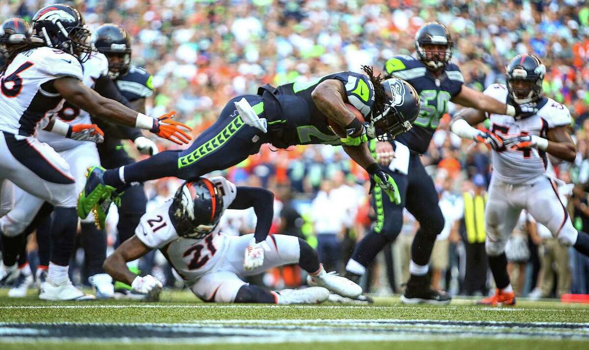 Seattle Seahawks player Marshawn Lynch flies into the endzone during a six yard run for a touchdown in overtime against the Denver Broncos on Sunday, September 21, 2014 at CenturyLink Field in Seattle. The Seahawks defeated the Broncos 26-20.