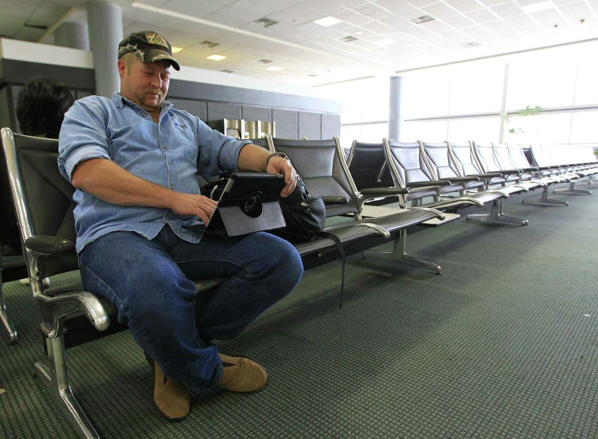 Billy Randles works on his iPad while waiting for his British Airways flight to Kenya in Terminal D at the Houston Intercontinental Airport, Monday, Jan. 28, 2013, in Houston. Houston Airport System working to develop a free Wifi network at IAH and HOU airports, which are some of the last in Texas to not offer free wifi. ( Karen Warren / Houston Chronicle )