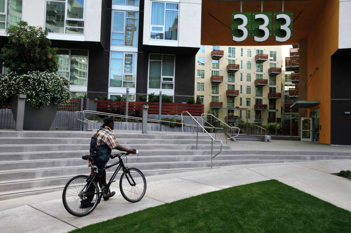 Clarence Cook walks his bike up to the office at 333 Harrison to apply for housing at the renovated former Stanford Hotel.