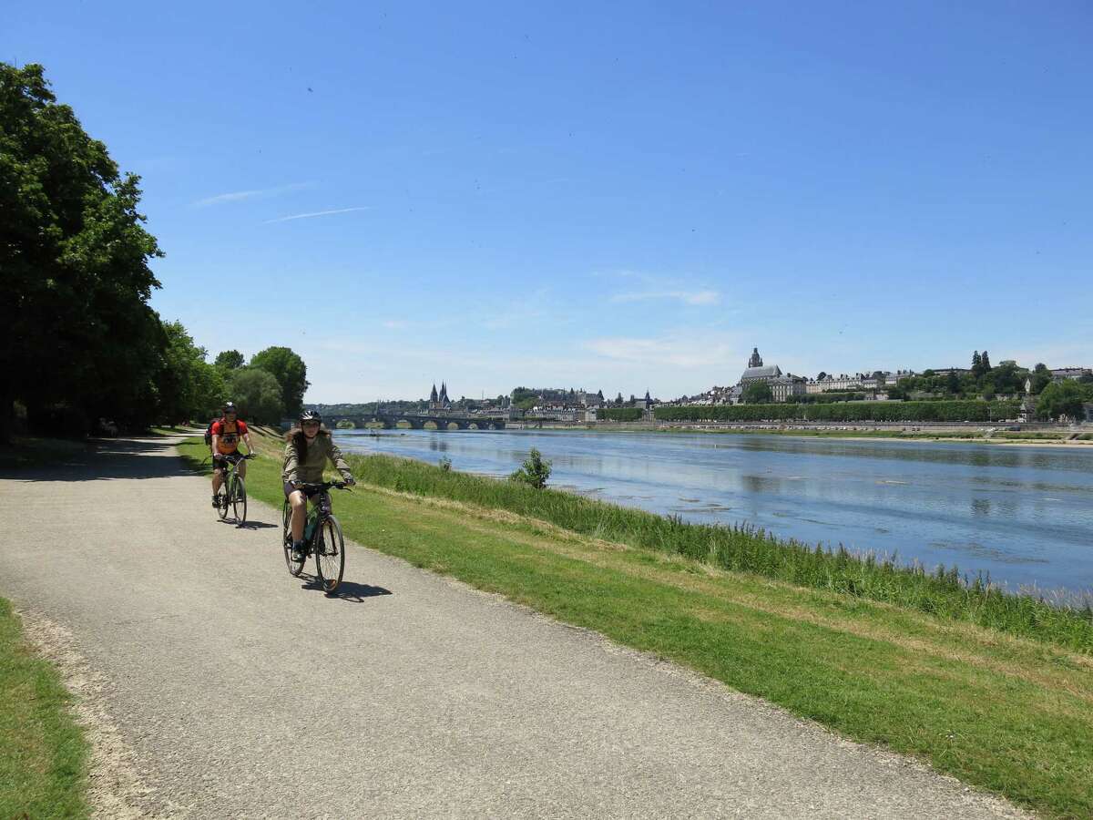 Cyclists bike along the Loire River near Blois, France.