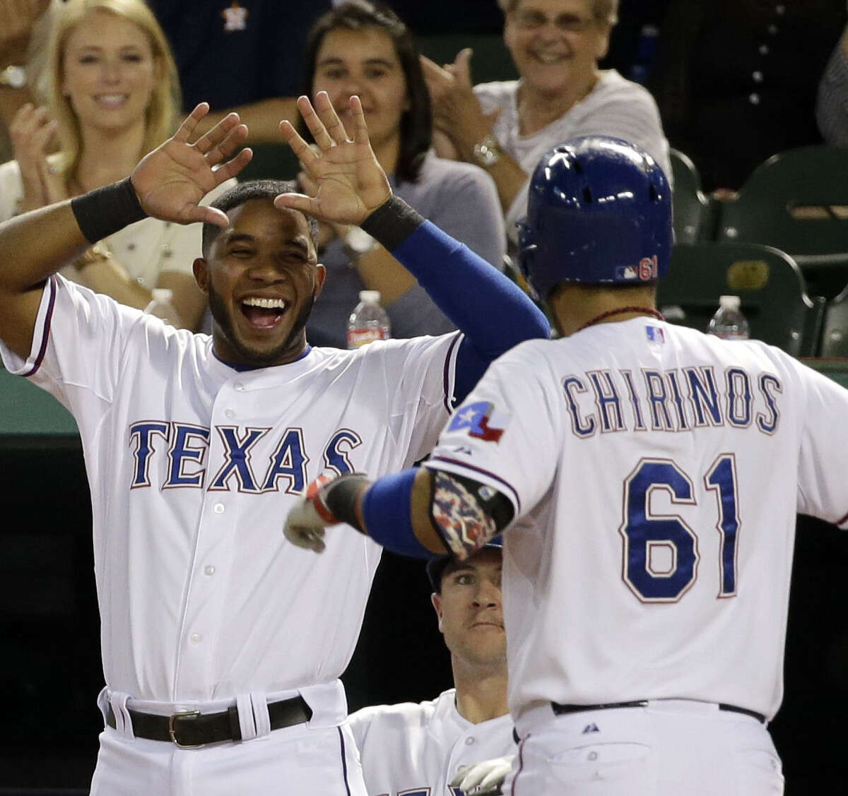 The Rangers' Elvis Andrus waits to greet Robinson Chirinos, who returned to the dugout after hitting a home run in the fourth inning in Arlington.