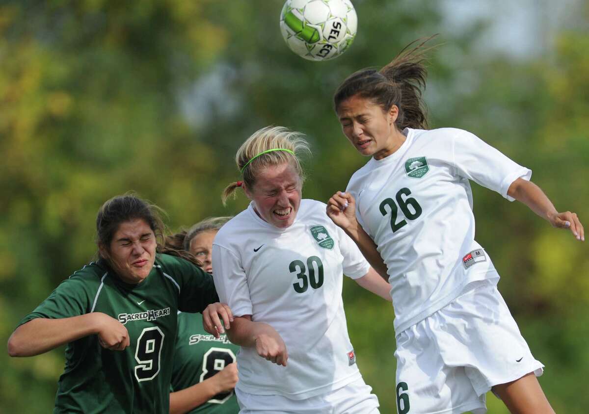 Sacred Heart's Alessandra Nocco (9) and Julia Pogge (8) defend Greenwich Academy's Kathryn Tenefrancia (30) and Marguerite Basta (26) from hitting a header during a corner kick in Greenwich Academy's 6-0 win over Sacred Heart in the high school girls soccer game at Convent of the Sacred Heart in Greenwich, Conn. Wednesday, Sept. 24, 2014.