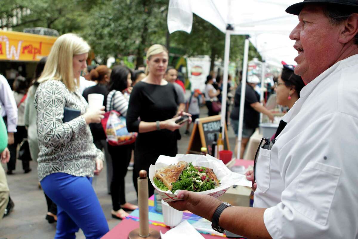 Chef Roy Rodriguez calls out customer names while serving healthy lunches during the City Hall Farmers Market on Wednesday, Sept. 24, 2014, in Houston.