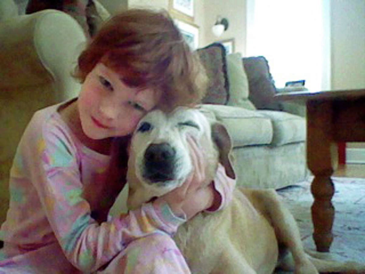 In this April 2012 photo provided by Jenny Hubbard, her daughter Catherine Hubbard hugs their dog Sammy at their home in Newtown, Conn. Despite her tragic death in the mass shooting at Sandy Hook Elementary School on Dec. 14, 2012, Catherine’s dream of helping animals is close to becoming a reality. By early August 2014, the state is expected to finalize transferring 34.4 acres of the former Fairfield Hills Hospital in Newtown to the Catherine Violet Hubbard Foundation Inc., which is raising money to fund the new Catherine Violet Hubbard Animal Sanctuary. (AP Photo/Jenny Hubbard)