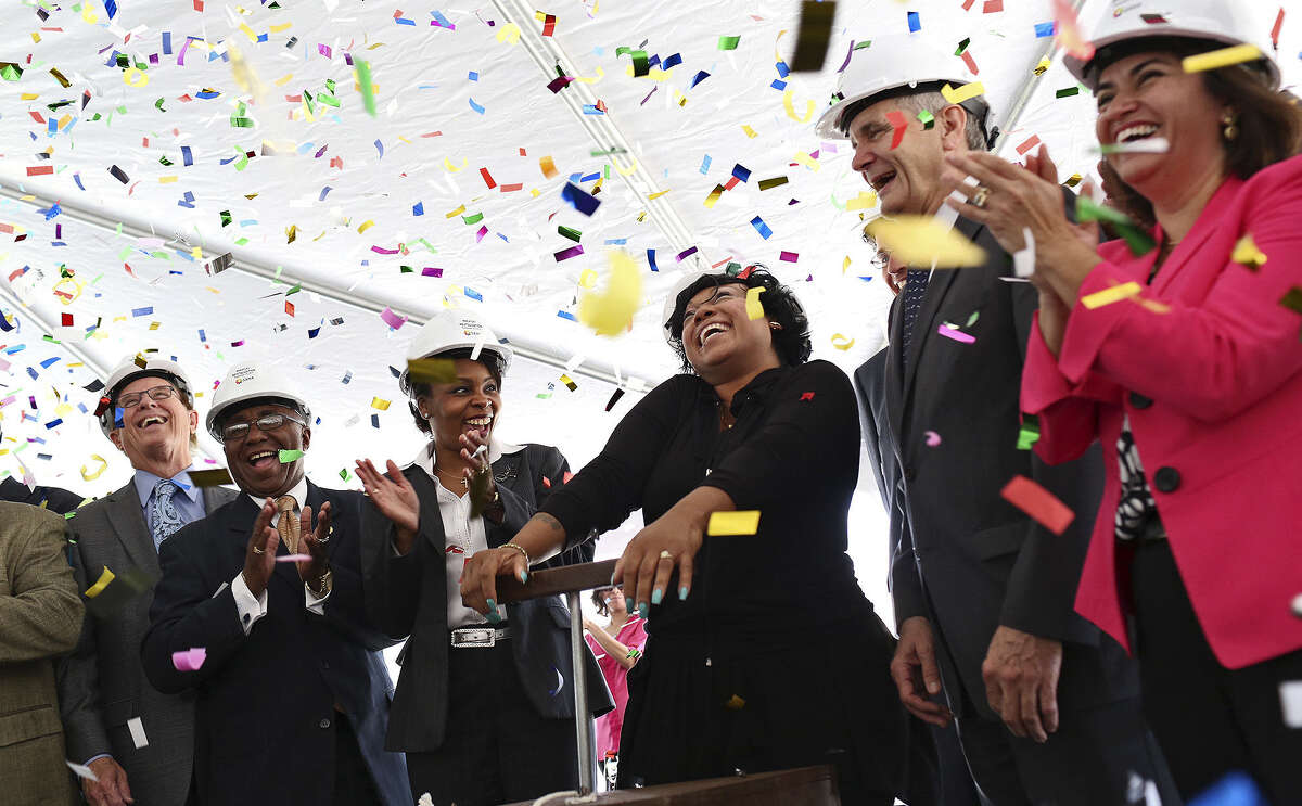 Former Wheatley Courts resident LaShawn Roberson (center) pushes down the ceremonial demolition detonator triggering confetti Thursday during the Wheatley Courts Demolition Celebration with Bexar County Judge Nelson Wolff (from left), City Councilman Keith Toney, Mayor Ivy Taylor, Congressman Lloyd Doggett and SAHA President and CEO Lourdes Castro Ramirez.