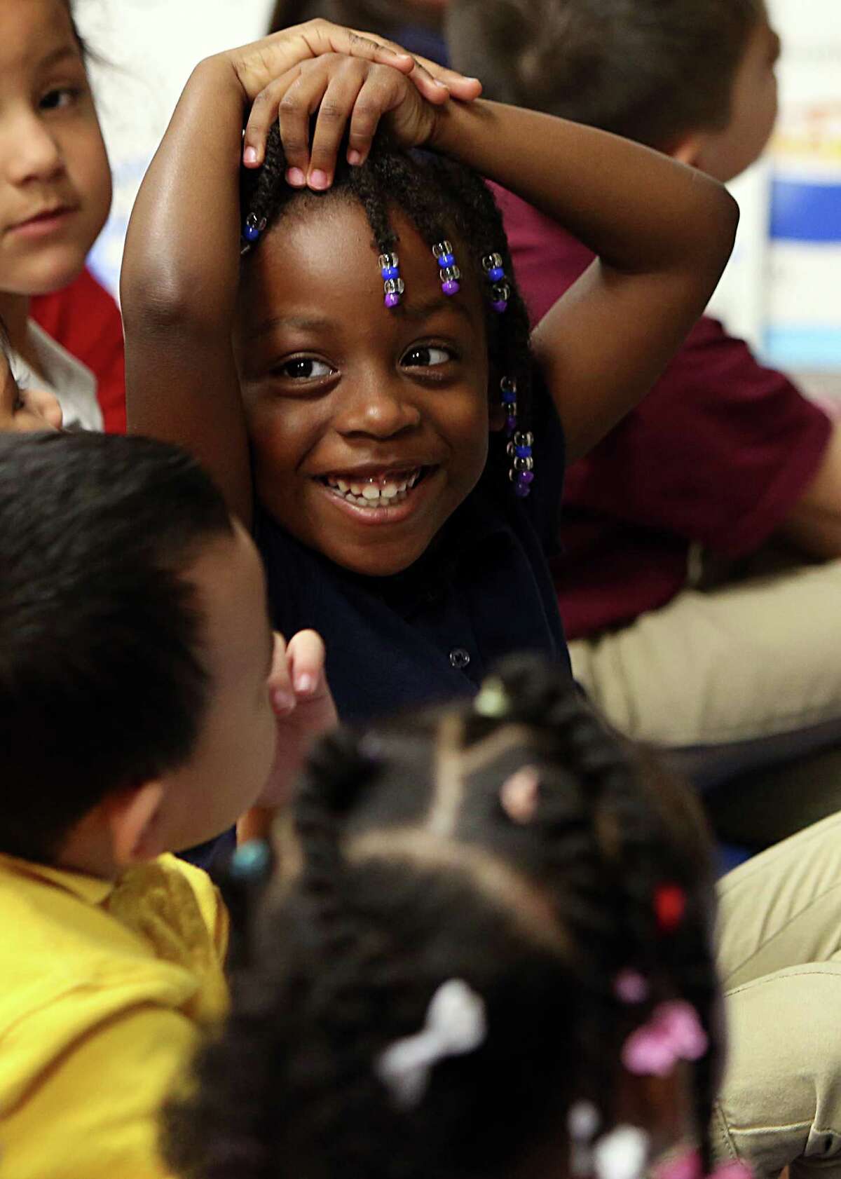 Trinidy Taylor, 4, smiles at teacher Lisa Joe during a morning pre-kindergarten lesson at Liestman Elementary School on Wednesday, Sept. 24, 2014, in Houston. A coalition of educators, business and civic leaders called Early Matters is pushing to expand high-quality, full-day pre-kindergarten for 4 year-olds in the greater Houston area. Alief ISD only offers half-day pre-kindergarten.