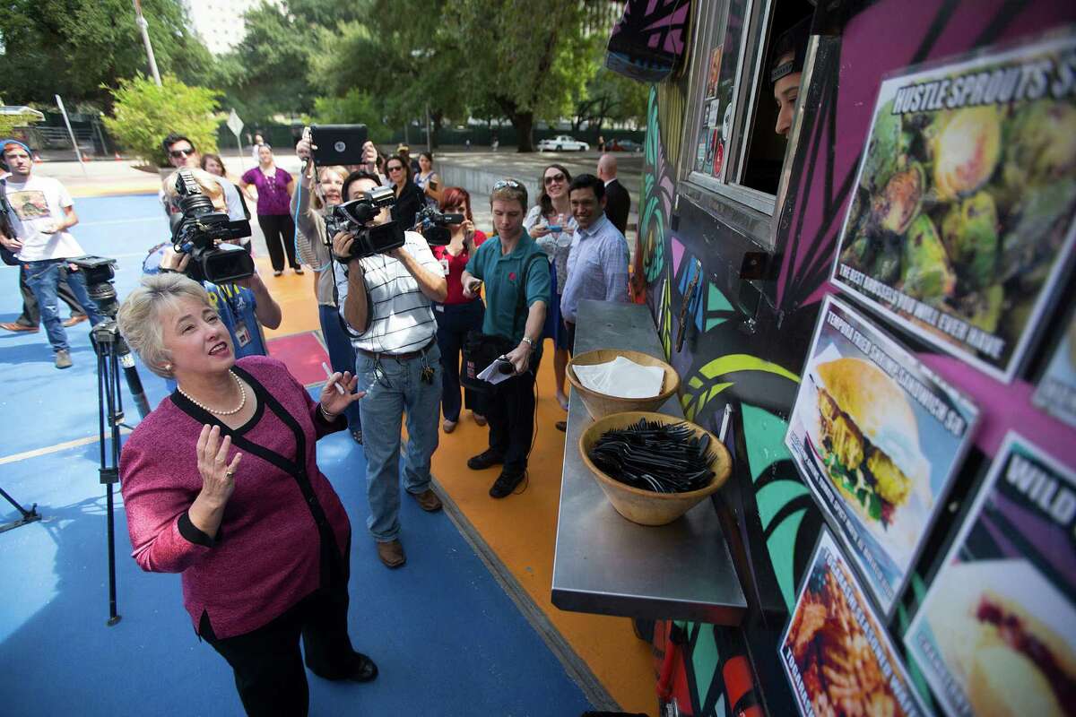 Mayor Annise Parker orders food from The Modular food truck, which is cooking with propane, outside ﻿the Houston Public Library's Central Library downtown Friday﻿.﻿
