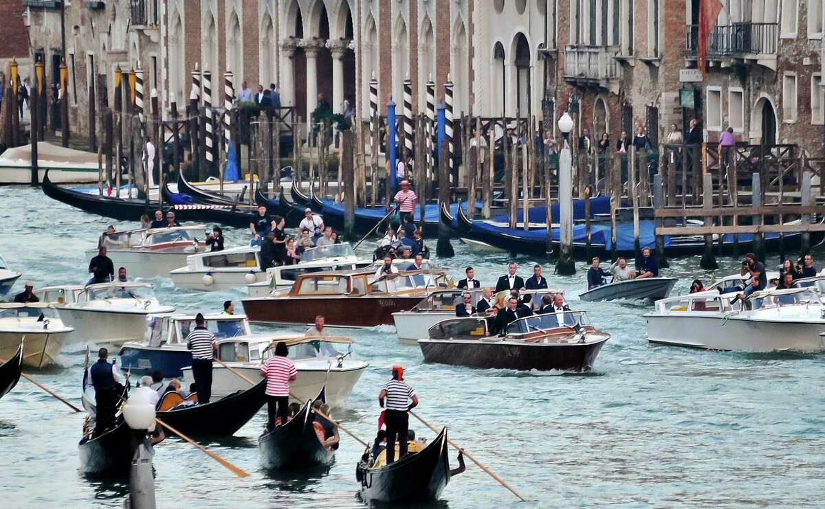 The boat carrying actor George Clooney and his guests cruises in front of media boats in the Grand Canal on its way to the Aman hotel ahead of his wedding in Venice, Italy, Saturday, Sept. 27, 2014.