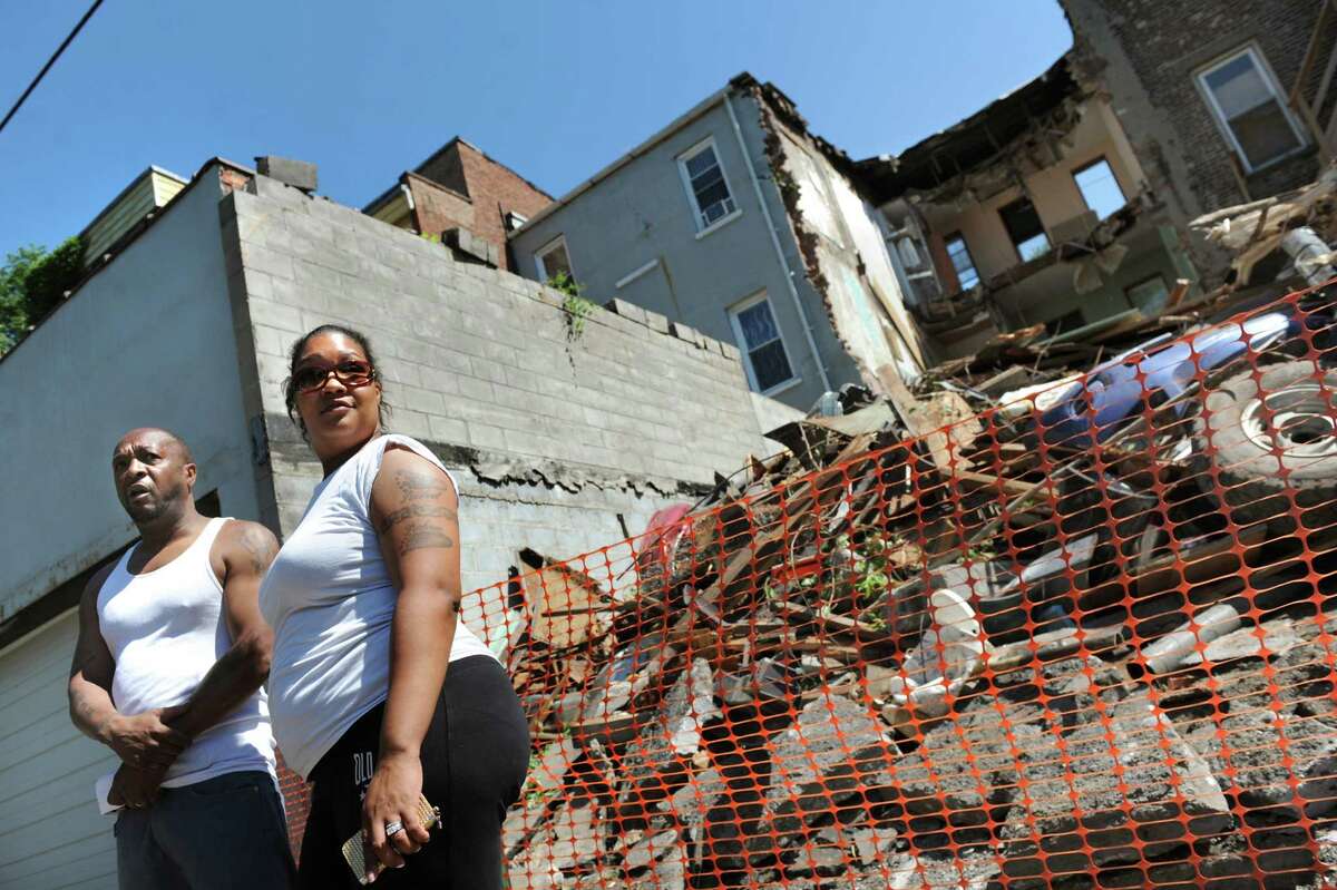 Homeowners Rasheem Robinson, left, and his wife, Jamie Robinson, talk about the building next door on Saturday, July 5, 2014, in Albany, N.Y. They had to leave their home because the building at 162 Clinton Ave. partially collapsed. (Cindy Schultz / Times Union) ORG XMIT: MER2014070515425709
