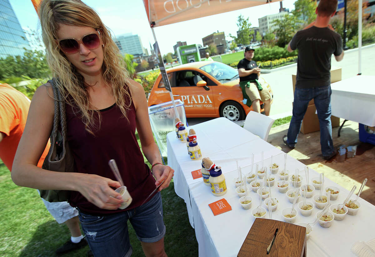 Katie Unrath, of North Columbus, Ohio, takes a sample of potato salad provided by Piada Italian Street Food during PotatoStock, Zack "Danger" Brown's Kickstarter-funded event, at the Columbus Commons in Columbus, Ohio on Saturday, Sept. 27, 2014. (AP Photo/The Columbus Dispatch, Jenna Watson)