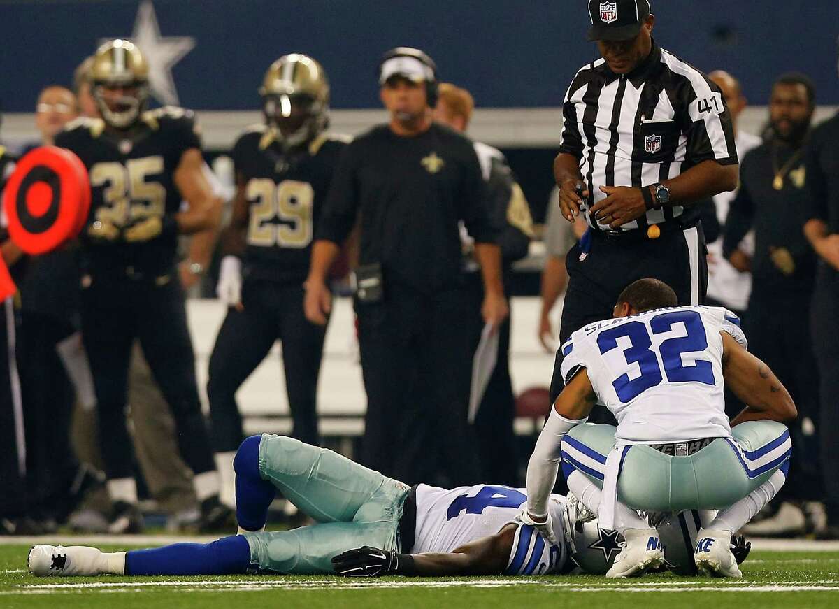 ARLINGTON, TX - SEPTEMBER 28: Orlando Scandrick #32 of the Dallas Cowboys tends to Morris Claiborne #24 of the Dallas Cowboys after he was injured against the New Orleans Saints in the first half at AT&T Stadium on September 28, 2014 in Arlington, Texas.