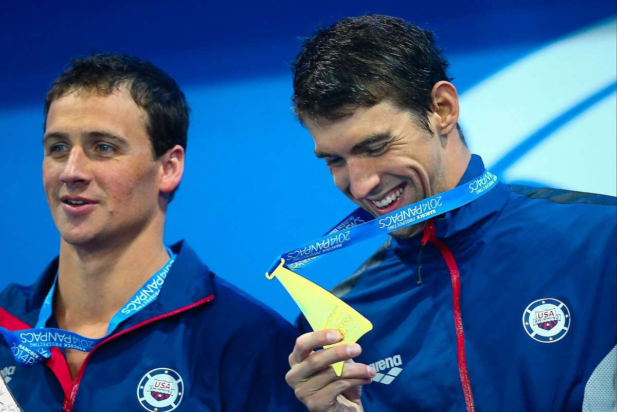 Ryan Lochte (L) and Michael Phelps (R) of the US react during the medal ceremony following the men's 200m butterfly final at the Gold Coast Aquatic Centre in Gold Coast on August 23, 2014. The Pan Pacific swimming championships continues until August 24. AFP PHOTO / PATRICK HAMILTON ---IMAGE RESTRICTED TO EDITORIAL USE - STRICTLY NO COMMERCIAL USE---PATRICK HAMILTON/AFP/Getty Images