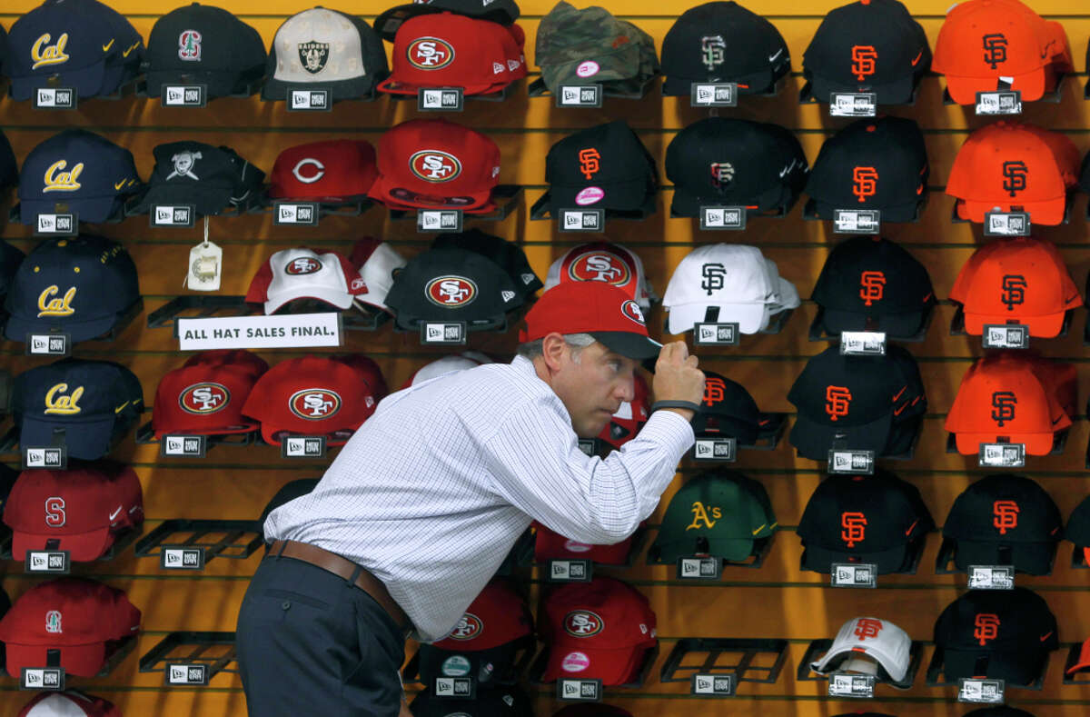 A customer tries on a 49ers cap at Lombardi Sports. The family-owned Russian Hill store will close in January after 66 years in business. in San Francisco, Calif. on Tuesday, Sept. 30, 2014. The popular, family-owned sporting goods store announced last week that it will be closing after 66-years in business. Supervisor David Campos plans to introduce legislation to create a registry of legacy businesses in the city.