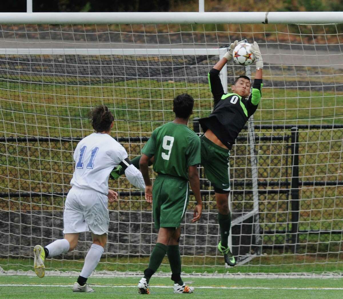 New Milford goalie Adam Llerena (0) jumps to make a save in New Milford's 4-0 win over Newtown in the high school soccer game at Treadwell Town Park in Sandy Hook, Conn. Tuesday, Sept. 30, 2014.