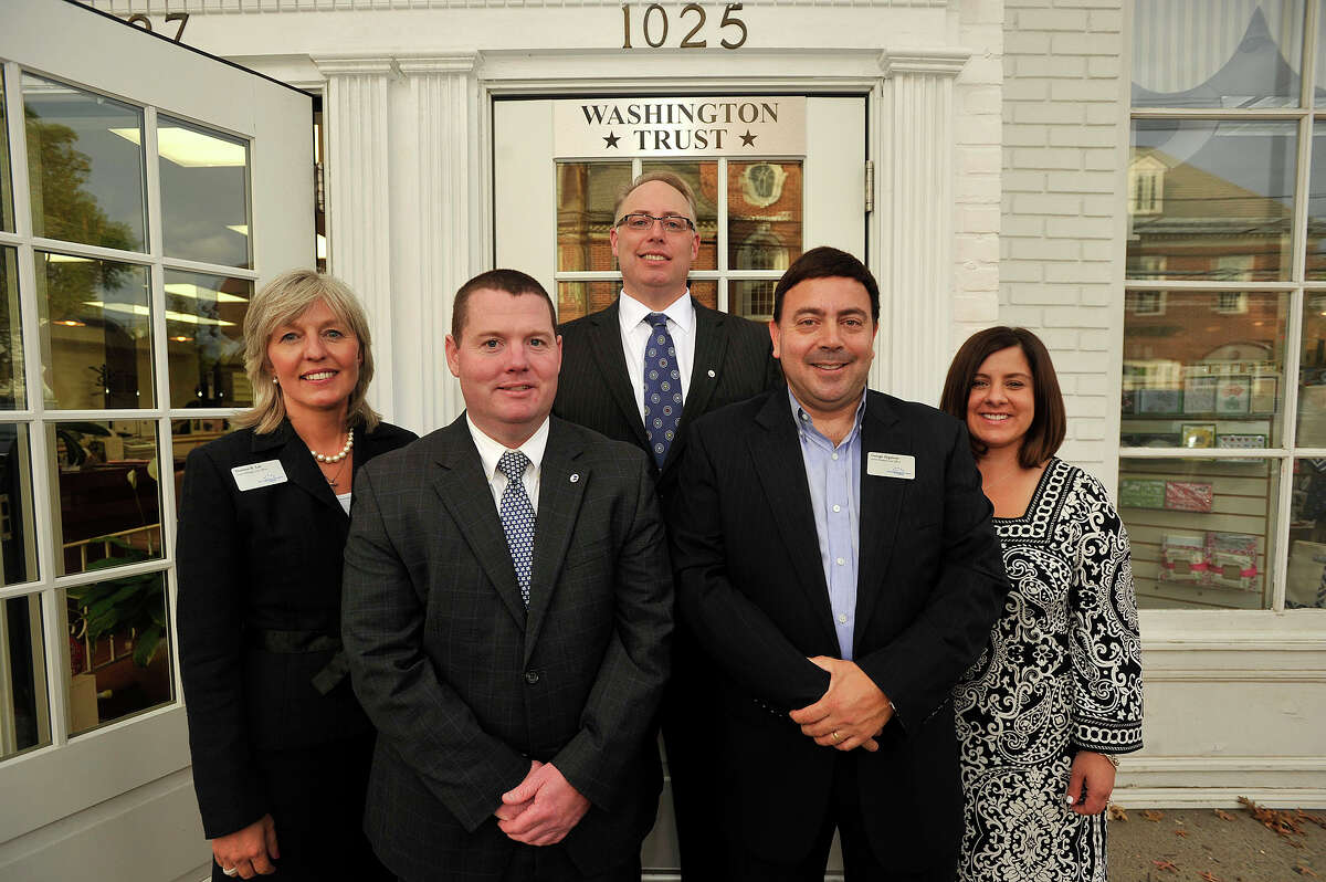 Washington Trust Mortgage Company employees from left: Darlene Lee, senior mortgage loan officer; Kevin Kinahan, mortage loan officer; James Gueltzow, executive vice president; George Zygmont, senior mortgage loan officer; Jaclyn Pioli, loan processor, pose for a photograph in front of Washington Trust's new location along Boston Post Road in Darien, Conn., on Tuesday, Sept. 30, 2014.