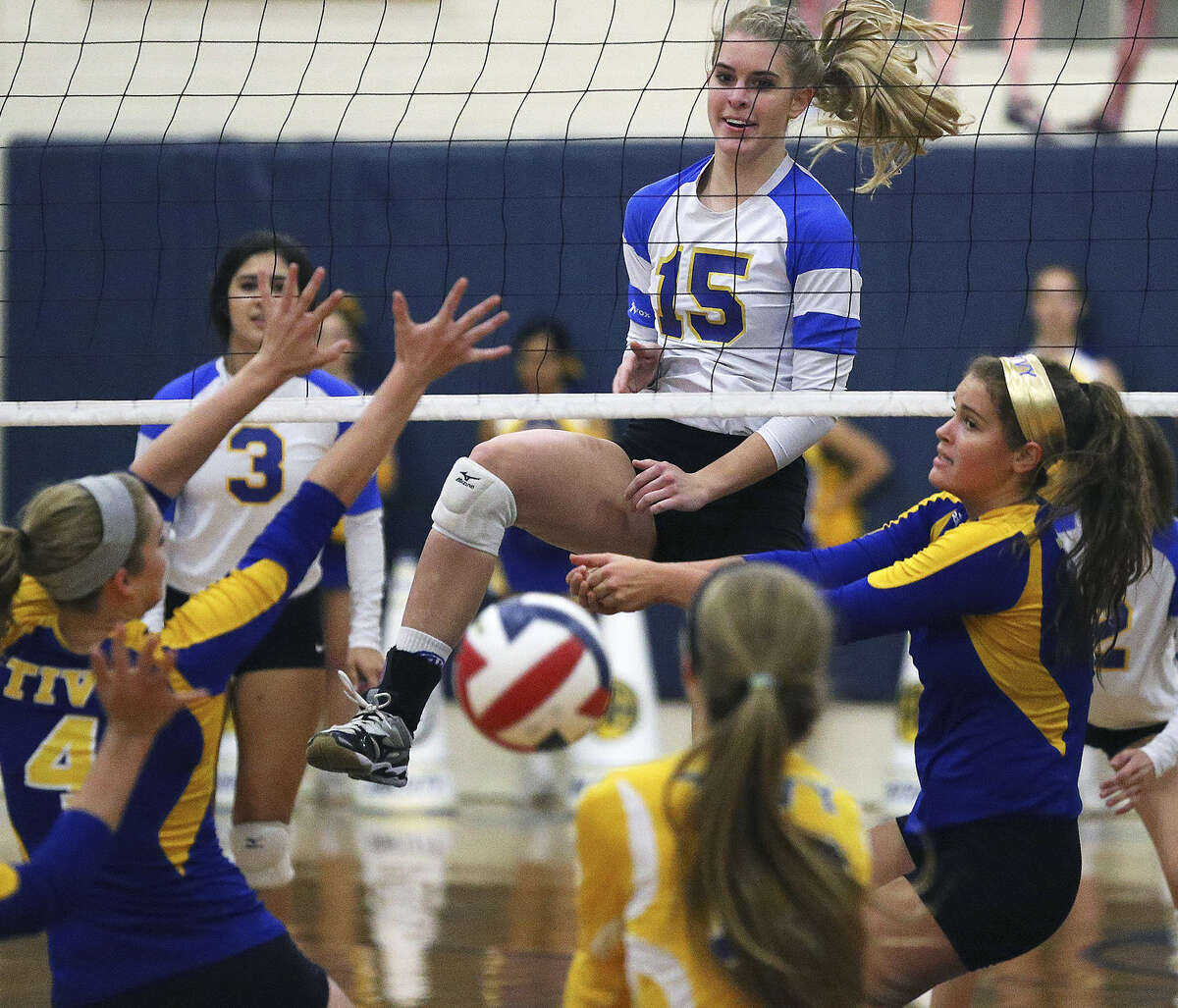 Alamo Heights' McKay Kyle (15) enjoys the scramble she created on the other side of the net with her spike during the Mules' three-set victory over District 27-5A rival Kerrville Tivy.
