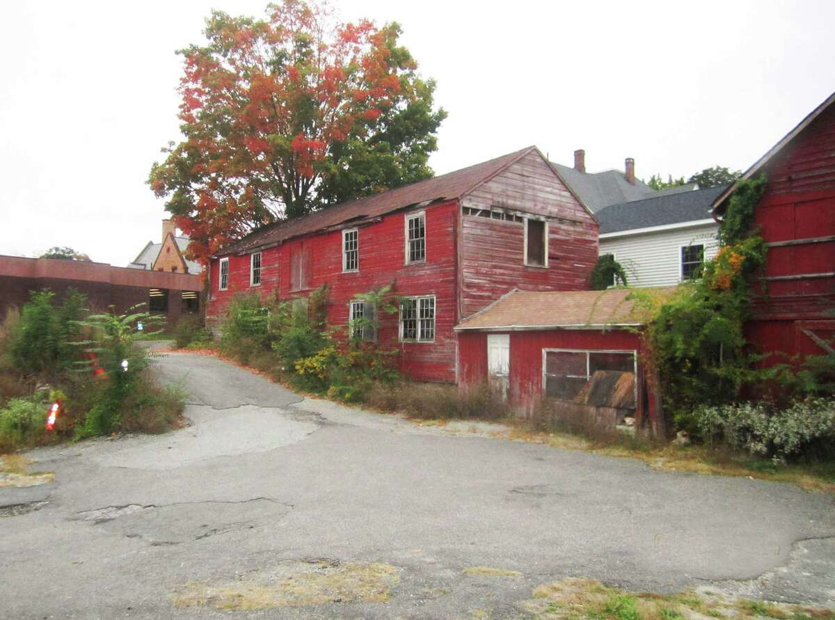 Town-owned property in the New Milford village center, including two old barns off Church Street, is now targeted for outdoor art use. The property, located between Main Street and East Street, adjoins the east side of the New Milford Public Library property, left. October 2014.