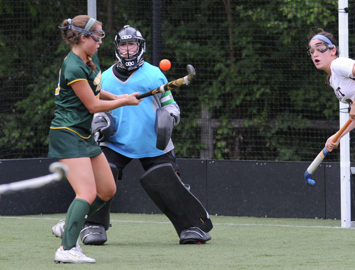 At center, Greenwich Academy goalie, Julia Booth, looks on as teammate Anna Khoury (#10), left, attempts to clear a Taft shot that Booth had blocked during in the match in field hockey at Greenwich Academy, Greenwich, Conn., Wednesday, Oct. 1, 2014. Greenwich Academy won the match, defeating Taft, 3-1.