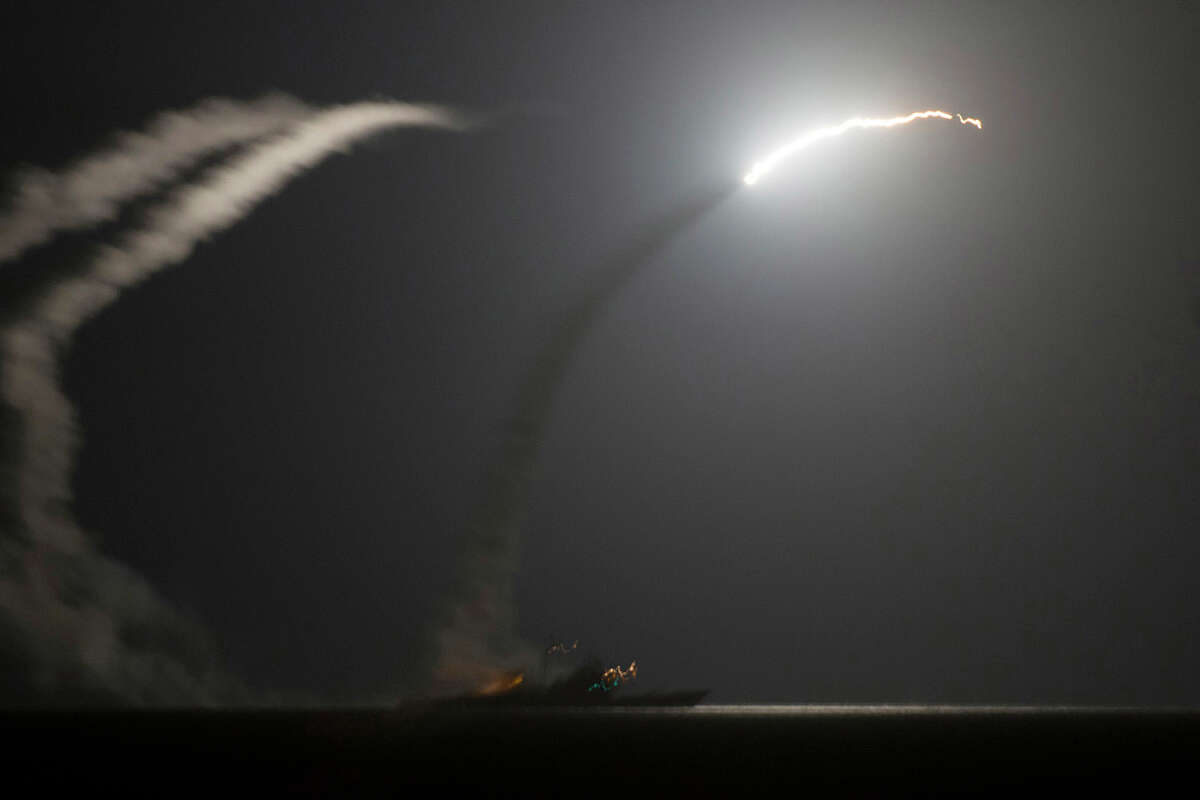 In this photo released by the U.S. Navy, the guided-missile cruiser USS Philippine Sea launches a Tomahawk cruise missile at Islamic State group positions in Syria as seen from the aircraft carrier USS George H.W. Bush in the Arabian Gulf on Tuesday, Sept. 23, 2014. Syria said Tuesday that Washington informed President Bashar Assad's government of imminent U.S. airstrikes against the Islamic State group, hours before an American-led military coalition pounded the extremists' strongholds across northern and eastern Syria.(AP Photo/Eric Garst, U.S. Navy)