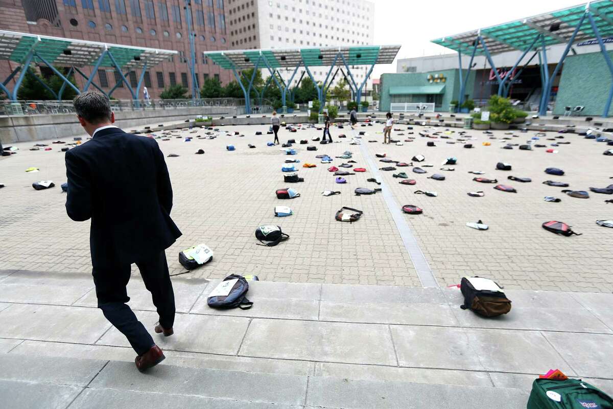 Michael Norvell looks at the one of the 1,100 backpacks, many with personal stories, representing the estimated 1,100 college students who die by suicide each year at Jones Plaza Thursday, Oct. 2, 2014, in Houston. 