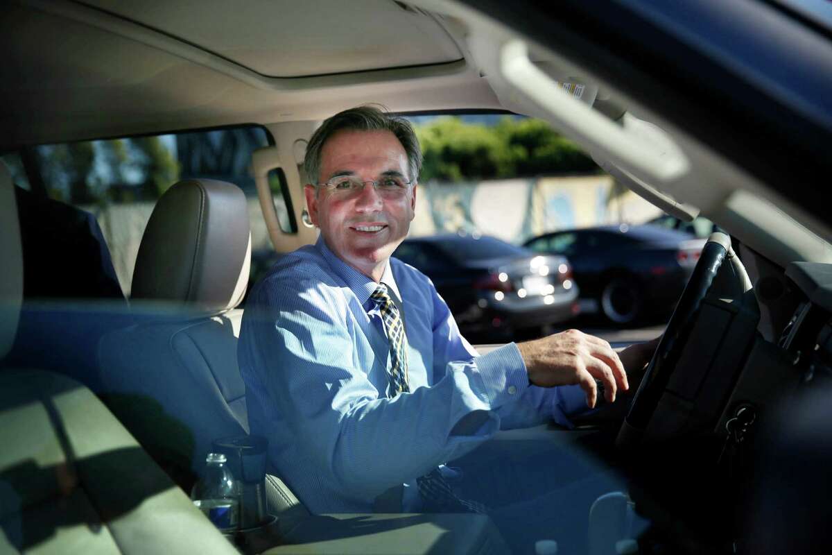 Billy Beane, Oakland Athletics general manager, smiles at fans after signing an autograph for Dave Chavez (not shown) of Alameda as he leaves the Oakland Coliseum on Wednesday, October 1, 2014 in Oakland, Calif.