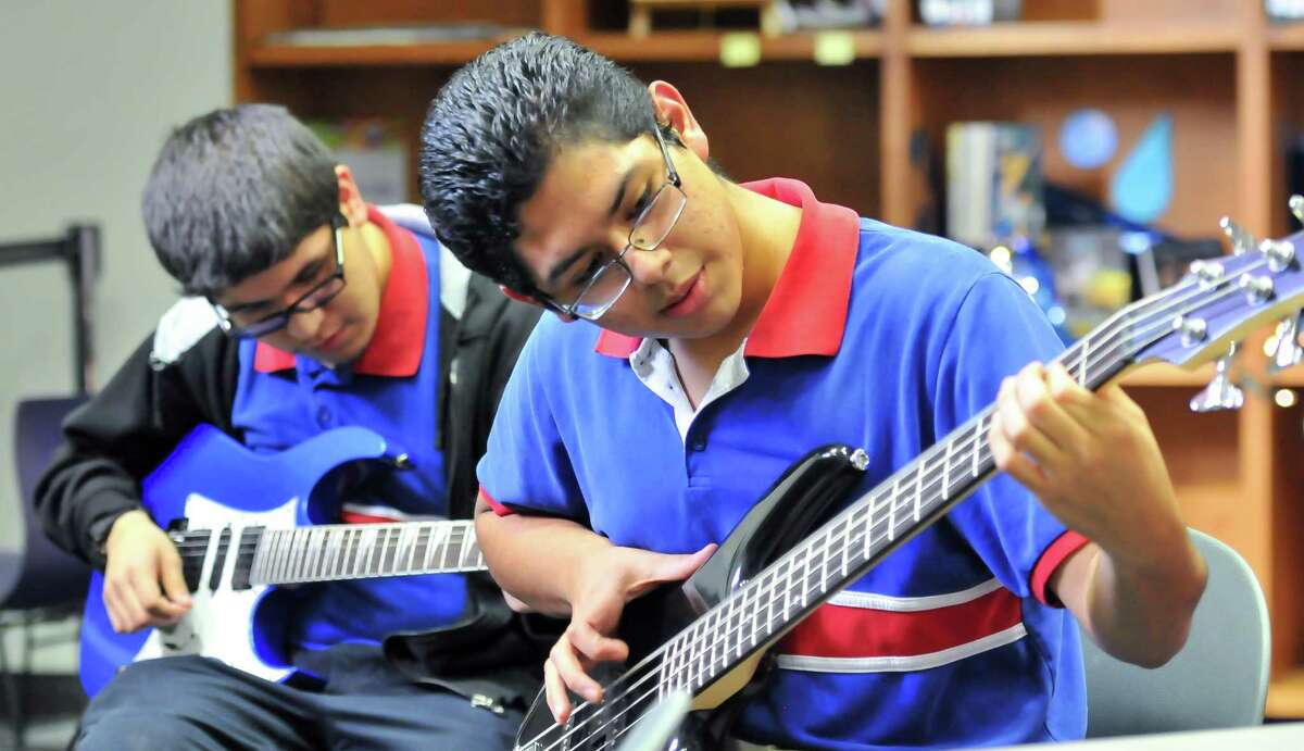 Christopher Gutierrez (left) plays guitar and Oswaldo Leija (right) plays bass during the Eclectic Electric event happening at the Central Library.