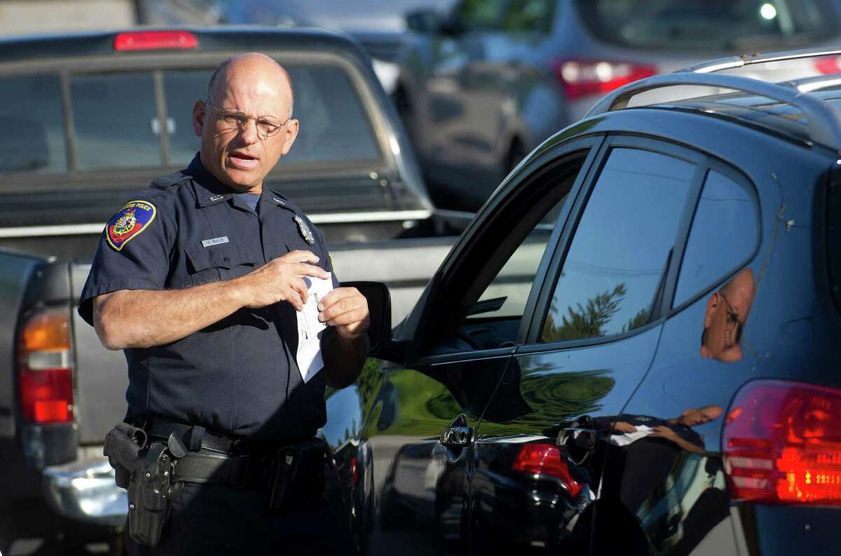 Officer Hugh Mullin tickets drivers during a traffic stop to ticket drivers for all violations, including blocking the box, at the intersection of Palmer Hill Road and Westover Road in Stamford, Conn., on October 3, 2014.